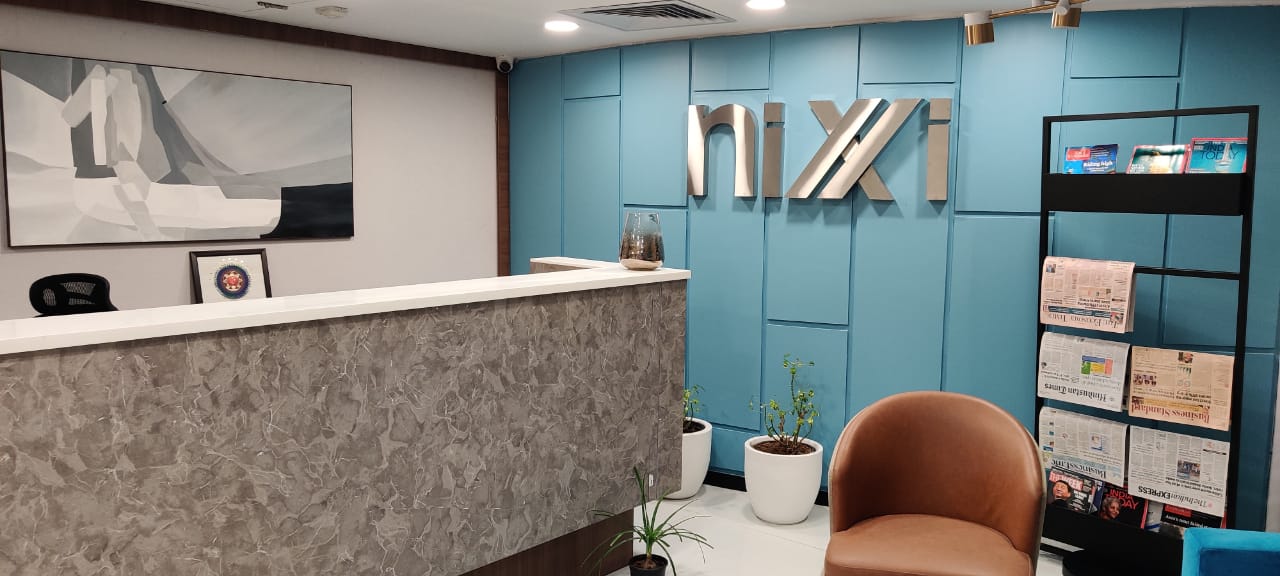 The NIXI office reception, with the NIXI logo mounted on the wall behind the front desk.